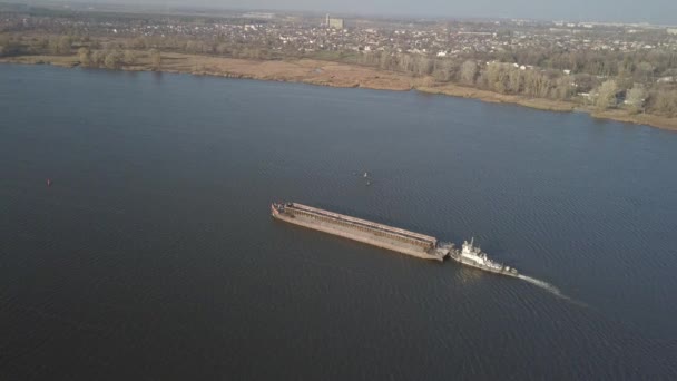 Een sleepboot duwt een schip stroomopwaarts van de rivier om bulkgoederen te vervoeren. Luchtfotografie met een quadcopter of een drone. Panorama van de Dnjepr - de belangrijkste watertransport slagader van Oekraïne — Stockvideo