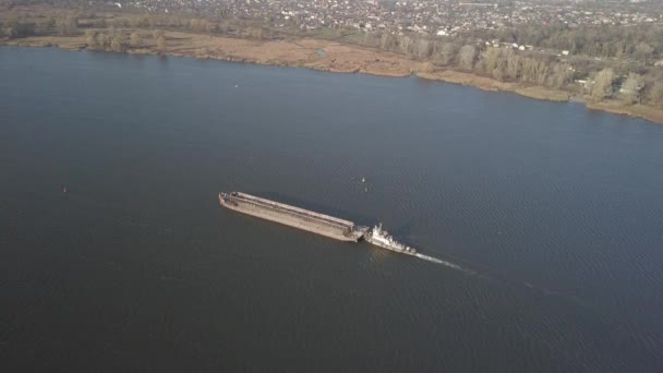 Vlečná loď tlačí bárku proti proudu řeky, aby přepravila sypké materiály. Letecká fotografie s quadcopterem nebo dronem. Panorama of the Dněpru - hlavní vodohospodářská tepna Ukrajiny — Stock video