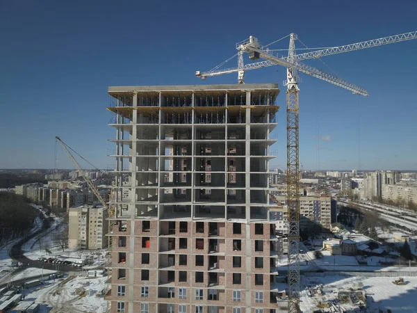 Lwów, Sychiw, Ukraina - 2 7 2020: Dźwigi wieżowe działają podczas budowy wielopiętrowego budynku. Nowe mieszkania dla mieszkańców i pomieszczenia biurowe. Ryzykowna praca na wysokości. — Zdjęcie stockowe
