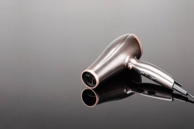 Gri ayna arka planda kahverengi saç kurutma makinesi