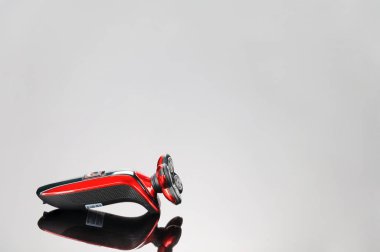 Elektrik kırmızı tıraş makinesi, gri ayna arka izole saç kesimi