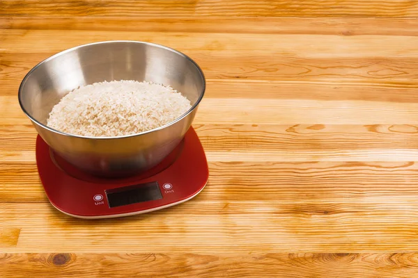 Рис в миске на электронном фоне из натурального дерева — стоковое фото