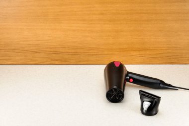 Fotokopi alanı ile odunsu mermer arka plan üzerinde saç kurutma makinesi