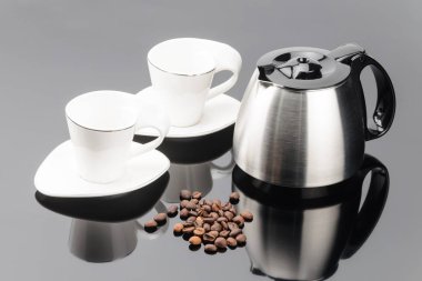 Gri ayna backgroun üzerinde coffe fasulye ve fincan ile Kahve demliği