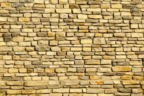 Primer plano de pared de piedra de granito amarillo desgastado — Foto de Stock