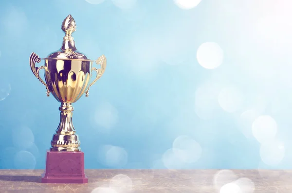 Altın kazanan trophy üzerinde gökyüzü arka plan ayakta ahşap Resepsiyon şenlikli bokeh arka plan bulanıklık