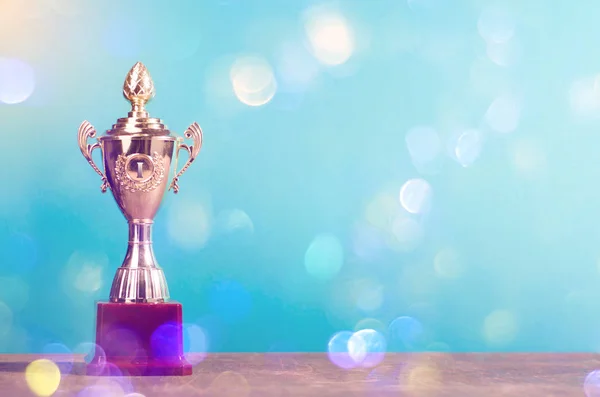 Altın kazanan trophy üzerinde gökyüzü arka plan ayakta ahşap Resepsiyon şenlikli bokeh arka plan bulanıklık