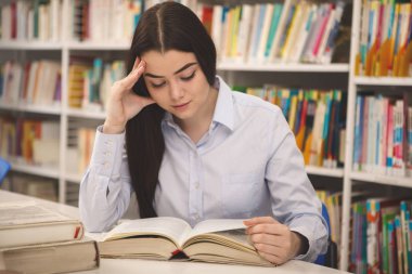 Bir proje üzerinde kütüphanede çalışan kitap, okuma uzun saçlı güzel kadın. Çekici kız öğrencinin Üniversitesi sınavlarına hazırlanıyor. Uluslararası öğrenci öğrenme zevk