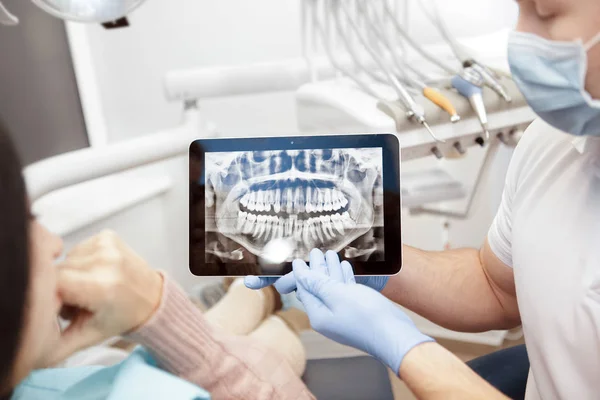 Sorunları tartışıyor. Çene ve diş gösteren profesyonel bir diş hekimi kadeh kırpılmış bir dijital tablet teknoloji gadget online sorunları Sağlık Tıp mesleğinin kullanarak onun hasta için röntgen kavramı yardım