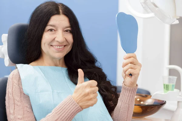 健康美丽的笑容 快乐的老年妇女微笑着高兴地显示竖起大拇指在牙科诊所病人病人服务退休健康医疗行业的人保险概念 — 图库照片
