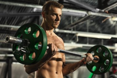 Egzersiz Seti. Güçlü bir emin yakışıklı adamın ile spor salonu motivasyon spor challenge rekabet kas fitness sağlık kavramı, bir halter egzersiz yaparken odaklı arıyorsunuz düşük açılı vurdu