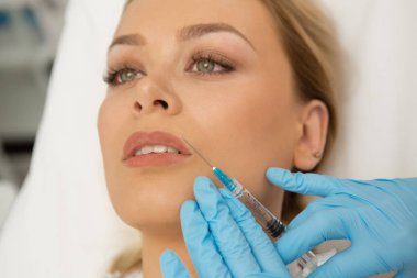 Muhteşem bir kadının Güzellik Kliniği'nde yüz muamele kapatın. Güzel kadın dolgu dudak büyütme plastik cerrahi kozmetik dudak Botox enjekte profesyonel güzellik uzmanı 