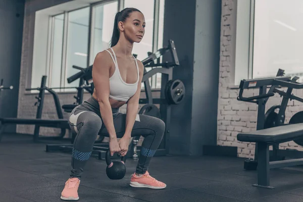 Düşük açılı bir güzel sporcumuz kettlebell spor salonunda, kopya alanı ile çalışma dışarı bir kadeh. Muhteşem kadın crossfit atlet kettlebell spor stüdyosu ile ağız kavgası yapıyor. Güç kavramı