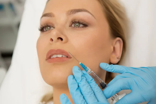 Muhteşem bir kadının Güzellik Kliniği'nde yüz muamele kapatın. Güzel kadın dolgu dudak büyütme plastik cerrahi kozmetik dudak Botox enjekte profesyonel güzellik uzmanı 
