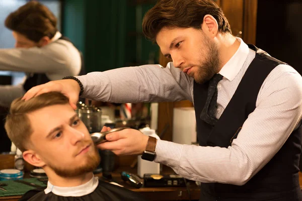 Молодий Красивий Професійний Перукар Працює Своїм Клієнтом Голиться Обрізаючи Бороду — стокове фото