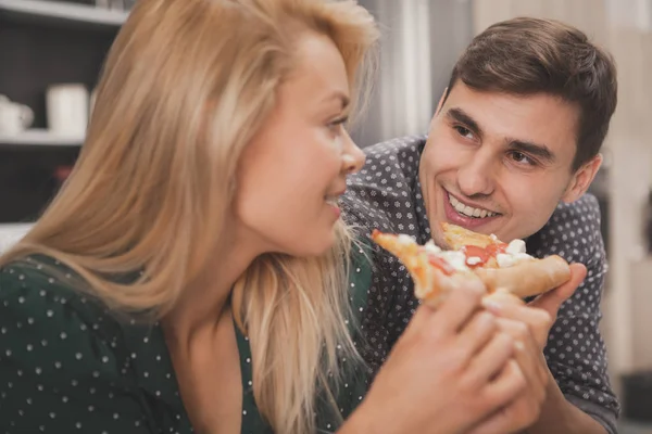家でおいしいピザを食べる彼女のハンサムな男に笑顔幸せな美しい女のクローズ アップ おいしいピザを食べて 素敵な恋人を見ているハンサムな男 ロマンス 家族の概念 — ストック写真