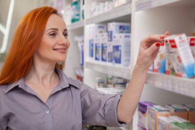 Mutlu sağlıklı kadın gülümseyerek, eczaneden ilaç ürünleri satın alma. Eczanede kopya alanı alışveriş güzel neşeli kadın müşteri. Satınalma, perakende, çeşitli kavramı