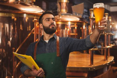 Taze inceleyerek sakallı profesyonel brewer Pano, tutan bir bardak bira yaptı. Bira bardağı kadar tutarak onun MICROBREWERY çalışan bira ustası. Üretim, gıda ve içecek sanayi kavramı