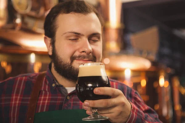 幸せな男性醸造家彼の目を閉じて 笑みを浮かべて楽しんでおいしい黒ビール コピー領域の臭いがするをクローズ アップ プロの Beermaker は彼のおいしい地ビールを楽しんでします リラックス レジャー 週末コンセプト — ストック写真
