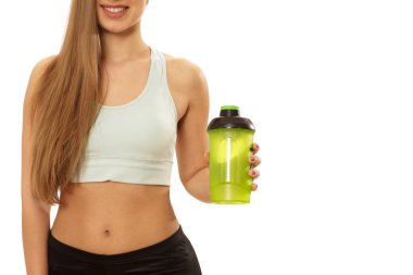 Genç mutlu güzel bir kadınla uygun doz ve tonda mükemmel vücut gülümseyen holding şişe su izole kopya alanı kırpılmış. Çalışma dışarı sonra neşeli fitnesswoman. Diyet, hidrasyon kavramı