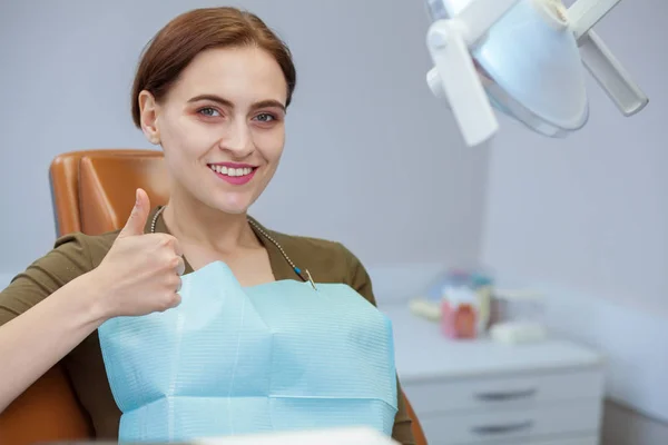 快乐美丽的女人坐在牙科椅上 微笑着露出大拇指 复制空间 有吸引力的女性患者在成功的口腔治疗后微笑 牙科理念 — 图库照片