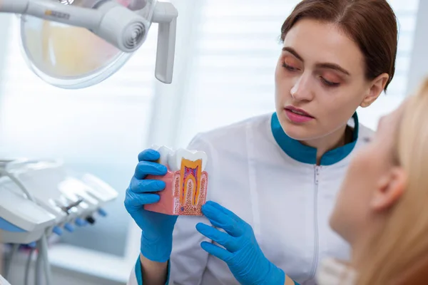 Młoda Kobieta Dentysty Gospodarstwa Formy Zęba Tłumacząc Coś Jej Pacjentowi — Zdjęcie stockowe