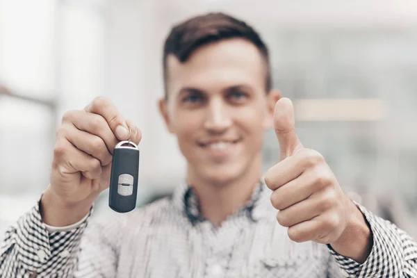 Joven comprando coche nuevo en el concesionario — Foto de Stock