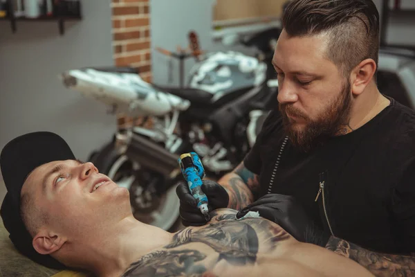 Handsome man getting a tattoo at alternative art studio — Stock Photo, Image