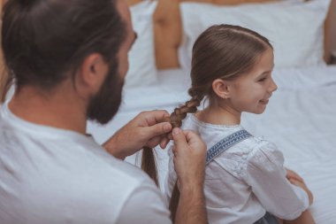 Evde istirahat küçük kızıyla olgun sakallı adam