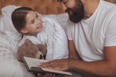 Evde istirahat küçük kızıyla olgun sakallı adam
