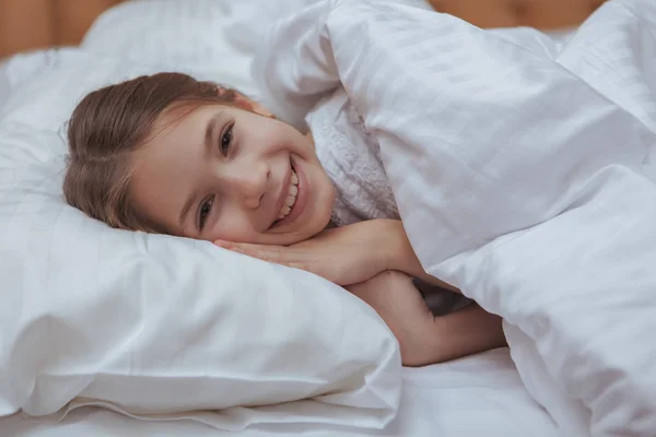 สาวน้อยที่น่ารักนอนบนเตียงที่บ้าน — ภาพถ่ายสต็อก