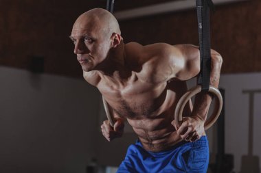 Jimnastik halkaları çalışma dışarı kaslı erkek crossfit atlet