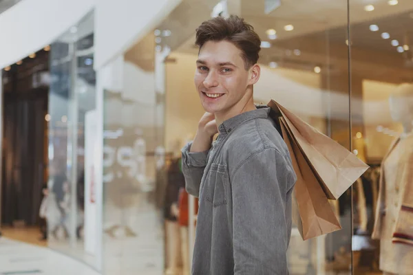 Bonito jovem fazendo compras no shopping — Fotografia de Stock