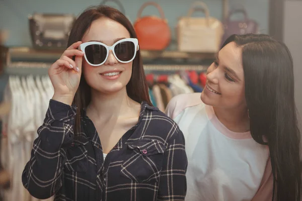 Encantadoras jovens mulheres comprando óculos — Fotografia de Stock
