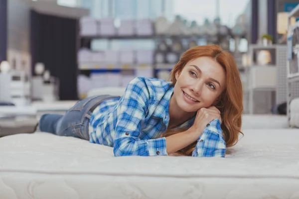 Belle femme achetant un nouveau matelas au magasin d'ameublement — Photo