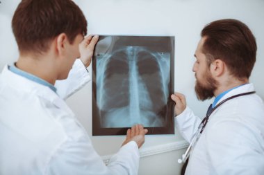 Hastanede x-ışını taramalarını tartışan iki erkek doktor