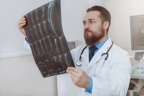 Maschio medico esaminando la scansione a raggi X nel suo ufficio — Foto Stock