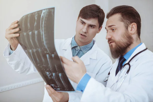 Due medici maschi che discutono di radiografie in ospedale — Foto Stock