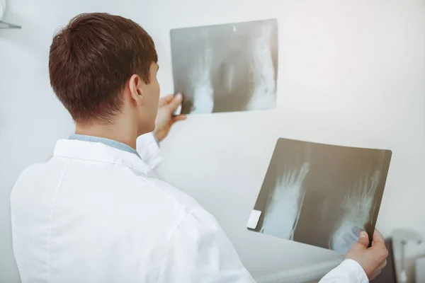 Maschio medico esaminando la scansione a raggi X nel suo ufficio — Foto Stock
