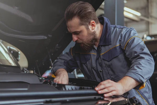 Mecánico barbudo trabajando en la estación de servicio de automóviles — Foto de Stock