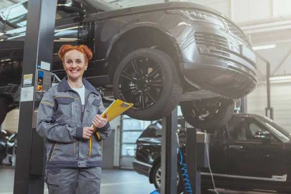 Female mechanic working at car service station