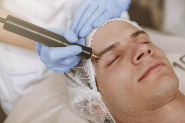Bonito homem recebendo tratamento de pele facial — Fotografia de Stock