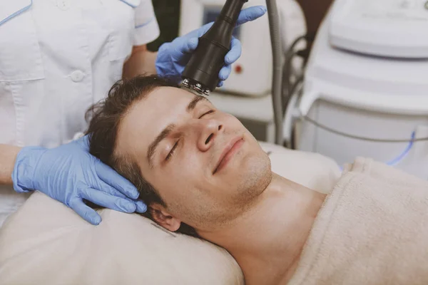 Bonito homem recebendo tratamento de pele facial — Fotografia de Stock