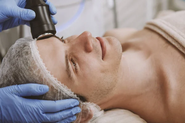 Hombre guapo recibiendo tratamiento facial de cuidado de la piel —  Fotos de Stock