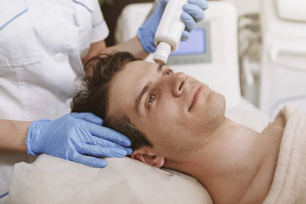Bonito homem recebendo tratamento de pele facial — Fotografia de Stock