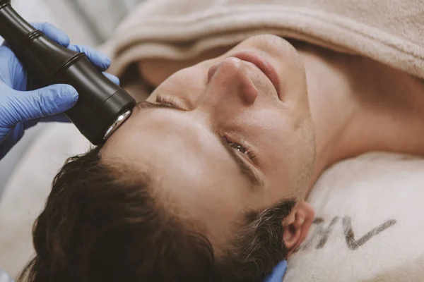 Bonito homem recebendo tratamento de pele facial — Fotografia de Stock