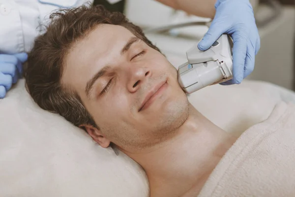 Hombre guapo recibiendo tratamiento facial de cuidado de la piel —  Fotos de Stock