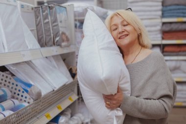 Mobilya dükkanından alışveriş yapan olgun bir kadın.
