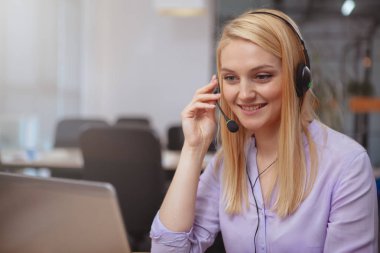 Friendly customer support operator with headset working at call 