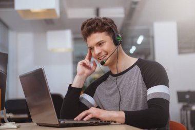 Friendly customer support operator with headset working at call 